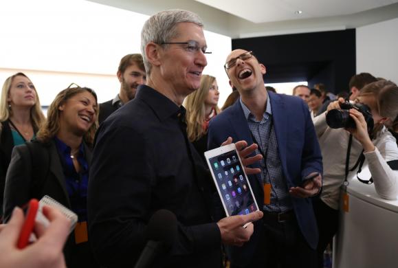 Apple CEO Tim Cook holds an iPad after a presentation at Apple headquarters in Cupertino