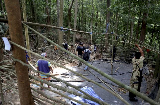 Security forces and rescue workers inspect an abandoned camp in a jungle in Thailand's southern Songkhla province