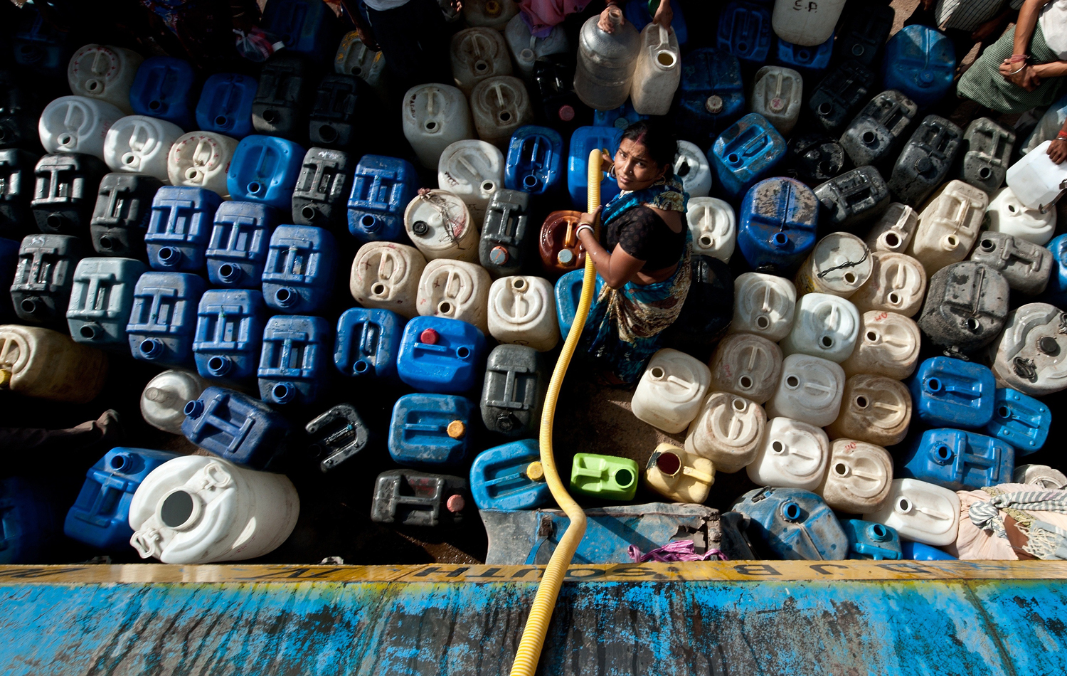 Image: TOPSHOTS  An Indian woman fills water co