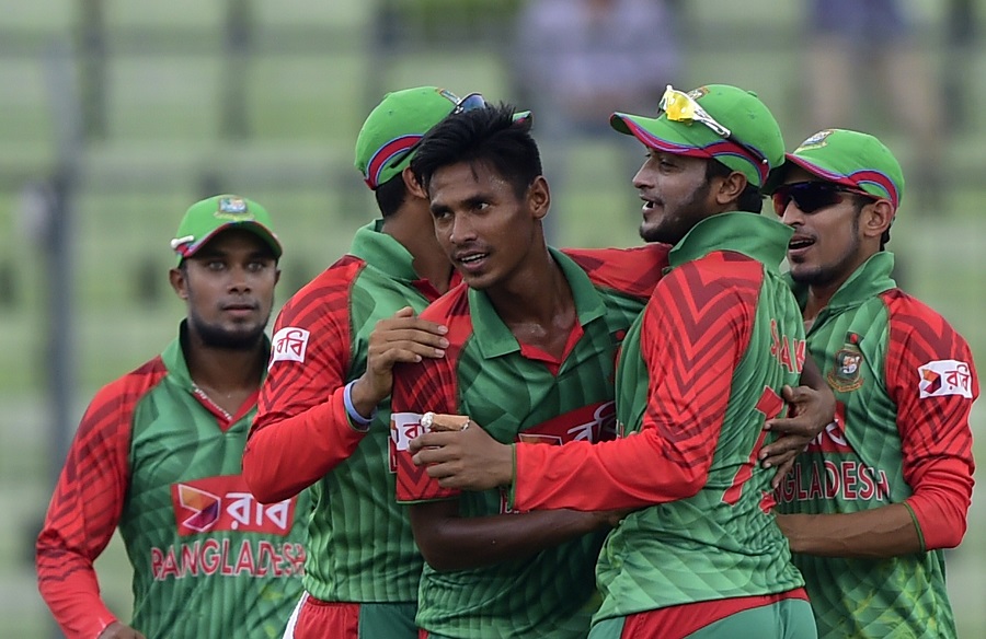 Bangladesh cricketer Mustafizur Rahman (C) celebrates with teammate Shakib Al Hasan (2R) and others after the dismissal of unseen Indian batsman Rohit Sharma during the third one day international (ODI) cricket match between Bangladesh and India at The Sher-e-Bangla National Cricket Stadium in Dhaka on June 24, 2015. AFP PHOTO/Munir uz ZAMAN        (Photo credit should read MUNIR UZ ZAMAN/AFP/Getty Images)