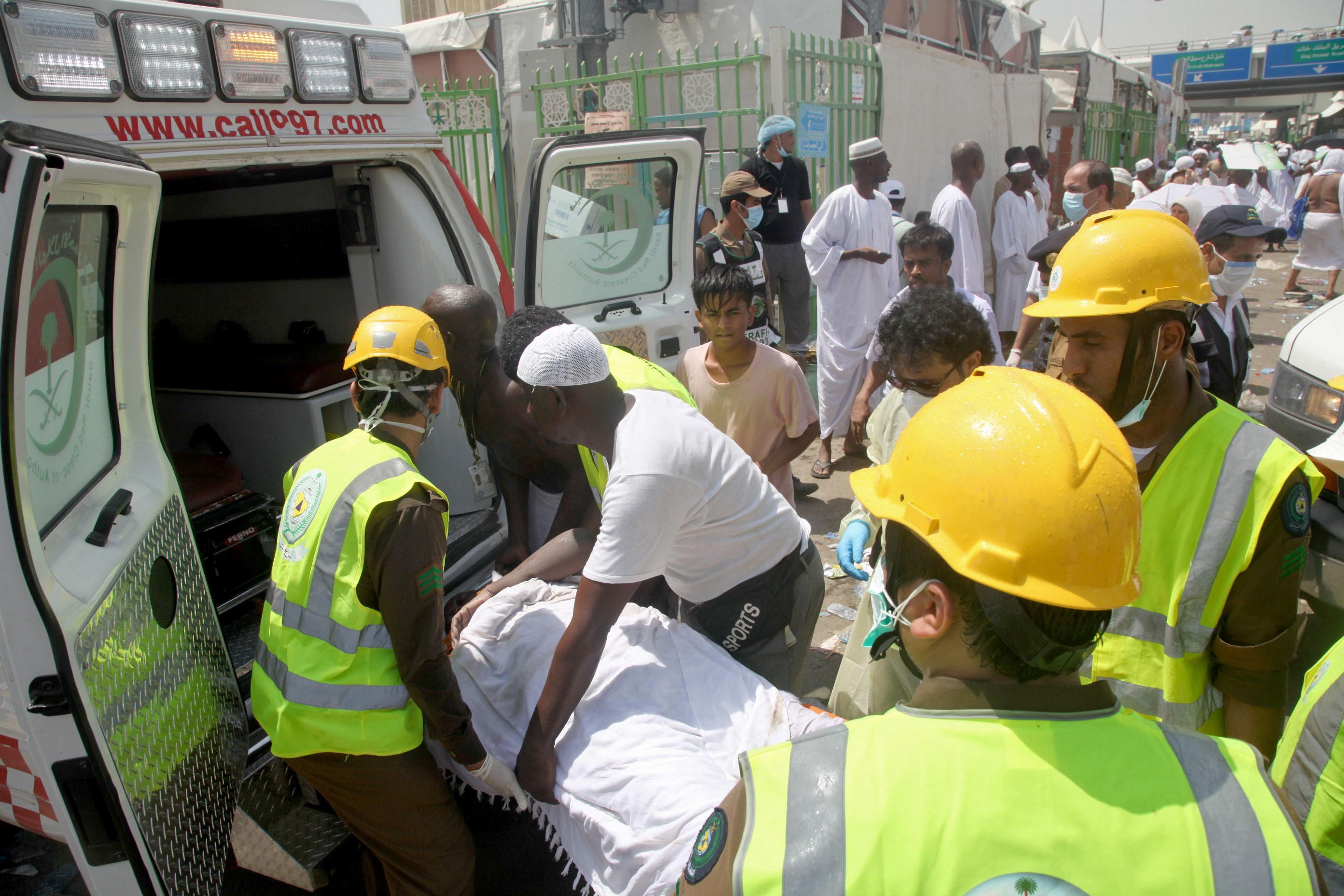 Saudi emergency personnel and Hajj pilgrims load a wounded person into an ambulance at the site where at least 450 were killed and hundreds wounded in a stampede in Mina, near the holy city of Mecca, at the annual hajj in Saudi Arabia on September 24, 2015. The stampede, the second deadly accident to strike the pilgrims this year, broke out during the symbolic stoning of the devil ritual, the Saudi civil defence service said. AFP PHOTO / STR        (Photo credit should read STR/AFP/Getty Images)